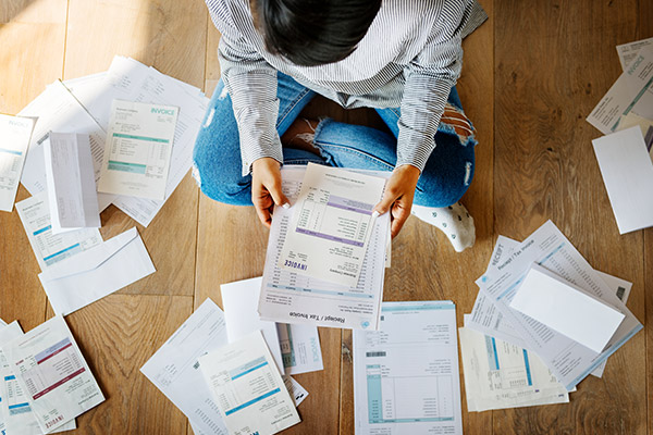 A person sitting on the floor surrounded by stacks of papers as they sort them